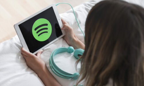 young-woman-holding-tablet-with-spotify-app